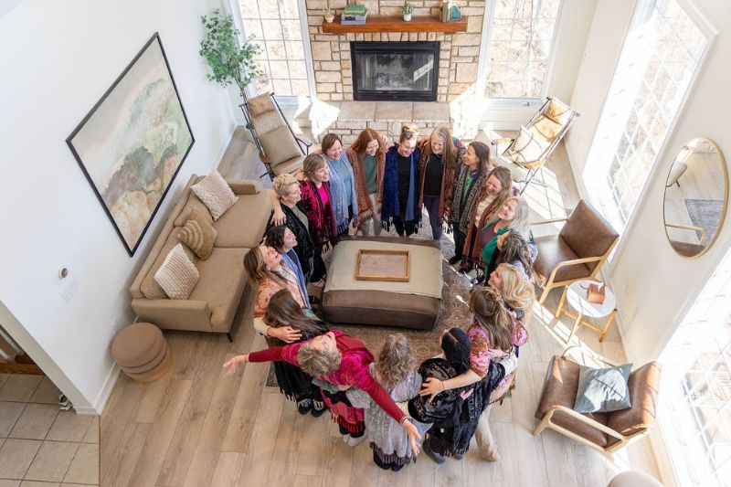 overhead shot of women standing in circle in living room at womens retreat